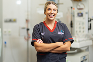 Female nurse stands in medical room smiling