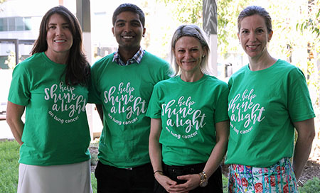 A man and three woman wearing t-shorts that read 'Help shine a light' stand outside a building.